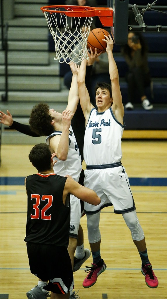 Glacier Peak&rsquo;s Justin Purcell (5) collects an offensive rebound during a game against Monroe at Glacier Peak High School on Tuesday. Glacier Peak beat Monroe 56-46. (Ian Terry / The Herald)