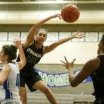 Lynnwood&rsquo;s Kaprice Boston (center) dishes the ball off to teammate Kia Crawford as Shorewood&rsquo;s Taryn Shelley (left) defends during a game at Shorewood High School in Shoreline on Friday. (Ian Terry / The Herald)