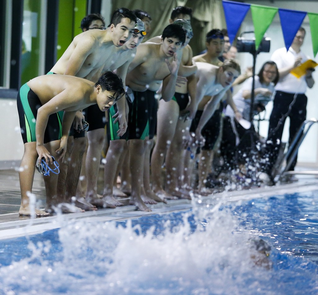 Jackson team members cheer during a meet against Kamiak on Tuesday at West Coast Aquatics in Mill Creek. (Ian Terry / The Herald)