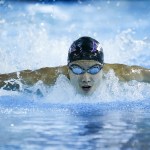 Kamiak&rsquo;s Maxwell Fang glides to victory in the 100-yard butterfly race during a meet against Jackson on Tuesday at West Coast Aquatics in Mill Creek. (Ian Terry / The Herald)