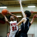 Marysville Pilchuck&rsquo;s Raequan Battle (21) goes up for a shot as Arlington&rsquo;s Max Smith defends during a game at Marysville Pilchuck High School on Wednesday. (Ian Terry / The Herald)
