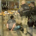 A man sits handcuffed after a stabbing in the food court at the Alderwood mall Sunday afternoon. Two people were injured in the incident, and the suspect is in custody. (Photograph by Michael O&rsquo;Leary)