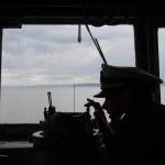 Ensign Tanner Roach takes a bearing from the bridge of the USS Gridley, the newest guided missile destroyer to be based at Naval Station Everett, as it begins heading toward Seattle for Seafair on Tuesday, Aug. 2, 2016. ( Andy Bronson / The Herald )