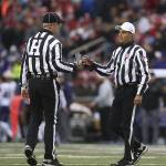 A referee hands over a flask to another referee after the object was thrown on to the field at the Apple Cup on Nov. 25, 2016, in Pullman. (AndyBronson / The Herald)