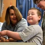 Katie Dawson, occupational therapist, coaches Jessie to wash his hands with Cheryl Pyles, Jessie&rsquo;s mother, looking on at the Providence Children&rsquo;s Center in Everett. The sessions coach Jessie on hand-eye coordination, washing hands, putting on socks and shoes and much more. (Kevin Clark / The Herald)