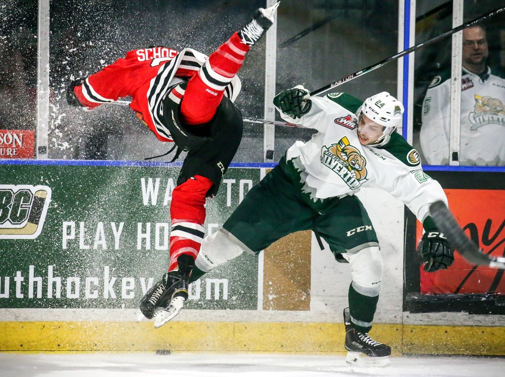 Winterhawks&rsquo; Alex Schoenborn catches air in the struggle to control the puck against Silvertips&rsquo; Lucas Skrumeda Friday night at Xfinity Arena in Everett, Washington of March 25, 2016. (Kevin Clark / The Herald)