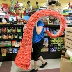 Jackie Sugita carries the now default tentacle display to the garbage Wednesday afternoon at Archie McPhees in the Wallingford neighborhood of Seattle. (Kevin Clark / The Herald)