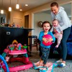 Carrying 4-month-old Haven, Apryl Roberts chases 2-year old Charlee around the house Wednesday, to the delight of all three. (Dan Bates / The Herald)