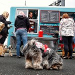 While their best friends sniff around, customers line up at a food truck in the parking lot outside Builders Exchange of Washington, on April 27, where Dawn Ford of The Seattle Barkery sells dog and human treats. Most of the early customers work at Builders Exchange, whose dog-friendly offices permit employees to bring small dogs to work with them. Four of them here are, from left, Doc, Zoey, Cleo and Zeus. (Dan Bates / The Herald)