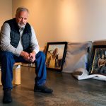 Late last week at the Schack Art Center, artist Chris Hopkins unpacks a few of his Tuskegee Airmen paintings while exhibit hanger, Josey Wise prepares walls nearby. The paintings uncovered behind him are &ldquo;The Flyer of the 332nd. (left) and &ldquo;The Commander and the Plan.&rdquo; (Dan Bates / The Herald)