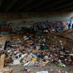 Police and social service workers search under an Everett overpass while administering a Point in Time survey of the homeless in Everett. The city of Everett is considering a lawsuit against Purdue Pharma, arguing the manufacturer of OxyContin is responsible for the community&rsquo;s surge in overdose deaths, homelessness and street crime. (Herald file)