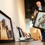 Recently at the Schack Art Center, artist Chris Hopkins unpacks a few of his Tuskegee Airmen paintings while exhibit hanger Josey Wise (background) prepares walls. The painting he carries is titled &ldquo;Roscoe Brown.&rdquo; The painting sitting against the wall at left is &ldquo;The Flyer of the 332nd.&rdquo; (Dan Bates / The Herald)