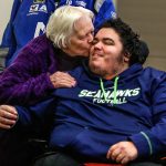 Terry Robertson, of Bow, plants a kiss on her grandson, Scotty Becktell, as the paralyzed man sits in Snohomish County Superior Court on Tuesday waiting for the sentencing of hit-and-run driver Scott Duncan. (Dan Bates / The Herald)