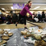 Ame Bridgman, a senior at Snohomish High School, tosses a piece of waste into a pile on the school&rsquo;s cafeteria floor during Waste Managementճ Trash on a Tarp initiative Tuesday. The program, which marked its first event in Snohomish County on Tuesday, aims to help students visualize the amount of trash created by daily activities. According to Waste Management, Snohomish County produces just under 3 million pounds of trash each day, about a third of which could have been recycled. (Ian Terry / The Herald)