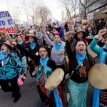 Native American women singing and drumming lead a women&rsquo;s march that brought tens of thousands Saturday in Seattle. (Elaine Thompson / Associated Pres)
