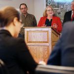 With two other judges, Gov. Jay Inslee (left) listens to Arlington mayor Barbara Tolbert (center) as she, Darrington Mayor Dan Rankin and Bob Drewel (right) practice their pitch for the America&rsquo;s Best Communities competition at the Arlington Airport on April 7, 2016, in Arlington. (Andy Bronson / Herald file)