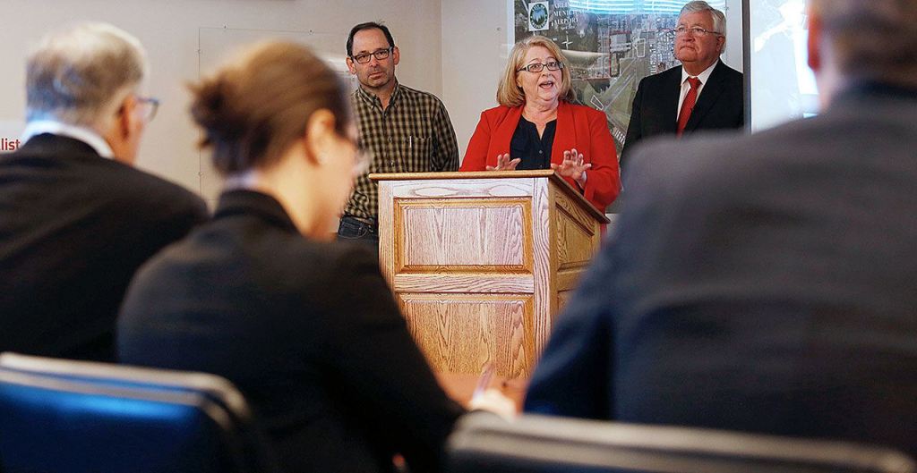 With two other judges, Gov. Jay Inslee (left) listens to Arlington mayor Barbara Tolbert (center) as she, Darrington Mayor Dan Rankin and Bob Drewel (right) practice their pitch for the America&rsquo;s Best Communities competition at the Arlington Airport on April 7, 2016, in Arlington. (Andy Bronson / Herald file)