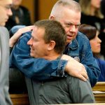 Tim Ward (top), who lost his wife, Brandy, in the 2014 landslide in Oso, hugs Dayn Brunner, who lost his sister, Summer Raffo, as Ward arrives for a session of King County Superior Court on Oct. 10, 2016, in Seattle. It was announced that a settlement had been reached in a lawsuit brought by survivors and family members of people killed in the slide against the state of Washington and a timber company that logged an area above the site of the slide. (Ted S. Warren / Associated Press)