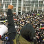 Seattle city councilwoman and socialist activist Kshama Sawant raises a fist over the crowd, as more than 1,000 people gather at Seattle-Tacoma International Airport, to protest President Donald Trump&rsquo;s order that restricts immigration to the U.S., Saturday, Jan. 28, in Seattle. The protest in Seattle was one of several across the country over the weekend. (Genna Martin/seattlepi.com via AP)