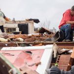 Jeff Bullard sits in what used to be the foyer of his home as his daughter, Jenny Bullard, looks through debris at their home that was damaged by a tornado, Sunday in Adel, Georgia. Gov. Nathan Deal declared a state of emergency in several counties, including Cook, that have suffered deaths, injuries and severe damage from weekend storms. (AP Photo/Branden Camp)