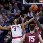 Gonzaga forward Johnathan Williams (3) and Loyola Marymount guard Buay Tuach (22) go after a rebound during the first half of a game Thursday in Spokane. (AP Photo/Young Kwak)