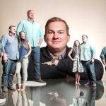 Julian Rinaldi of People Prints 3D is surrounded by a model of himself and another of him with his girlfriend, Adrienne Ockrymiek, at his Philadelphia business. (Michael Bryant / Philadelphia Inquirer)