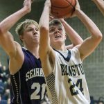 Arlington&rsquo;s Drew Bryson attempts a shot with Jesse Keltner of Anacortes defending during a game in December at Arlington High School. (Kevin Clark / The Herald)