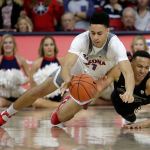 Arizona center Chance Comanche (left) and Washington forward Dominic Green battle for a loose ball during the first half Sunday in Tucson, Arizona. (AP Photo/Rick Scuteri)