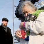 Celia Strong carries the ashes of her husband, Alfred Hollenbeck, to the rail for scattering off the coast of Hat Island on Sunday afternoon. (Kevin Clark / The Herald)