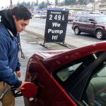 Andrew Caindoy pumps gas at General Brushless Car Wash, a full-service gas station and car wash in Everett. (Kevin Clark / The Herald)