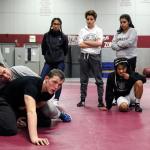 Cascade wrestling coach Brooklyn Obregon (far left) demonstrates a technique on Adam Holston during practice on Jan. 18 in Everett. After the death of his father, Jery, in June of 2016, Holston moved in with Obregon and his wife, Cindy. (Kevin Clark / The Herald)