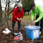Dave Bain (right) and Larry Asmann work to collect water samples from North Creek in Bothell on Dec. 3. (Ian Terry / The Herald)