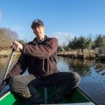 Eric Adman canoes past a restoration planting site, at right, along Swamp Creek on Dec. 20 in Kenmore.(Andy Bronson / The Herald)