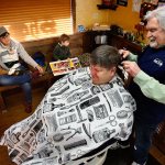 Regular customer Tamara Stramel waits to get her two boys haircuts after Don Baird, 76, finishes with Rick Duell&rsquo;s hair Friday at his Silver Lake area shop called Rusty Cuts Barbershop. Baird built the shop using some nice, old barnwood, so when he had a pile of it left over, he decided to build the political statement out back with the lumber. (Dan Bates / The Herald)