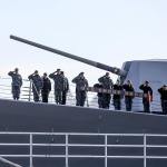 Naval personel salute as family and friends motor to the coast of Hat Island to scatter the ashes of Alfred Hollenbeck on Sunday afternoon. (Kevin Clark / The Herald)