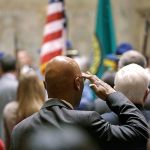 Rep. John Lovick, D-Mill Creek, salutes the flag carried by an honor guard at a joint session of the Legislature on Wednesday, Jan. 11, in Olympia. (AP Photo/Elaine Thompson)