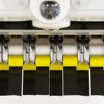 At Boeing&rsquo;s Composite Wing Center, carbon-fiber tape hangs from an Automated Fiber Placement machine before a test. The new 777X will be made with composite materials throughout the plane. (Andy Bronson / The Herald)