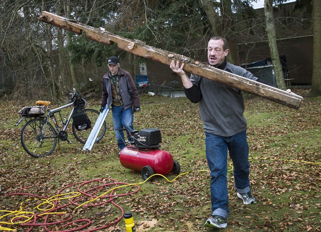 Tony Thompson (left) and Gary Michaels gather supplies to install a community living unit at the new homeless students living site at Good Shepherd Baptist Church on Jan. 17 in Lynnwood. Michaels, who attends Edmonds Community College, is one of the first residents to live on the site organized by Reverend Jean Kim. (Daniella Beccaria / The Herald)