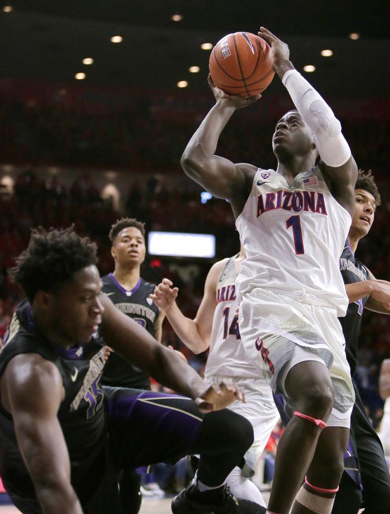 Arizona guard Rawle Alkins (1) draws the foul on Washington forward Noah Dickerson (15) during the second half Sunday, Jan. 29, in Tucson, Ariz. (AP Photo/Rick Scuteri)