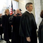Justice Charles Wiggins (third right) playfully takes a photo as he begins to head into the House chambers for a joint session of the Legislature on Wednesday, Jan. 11, in Olympia. (AP Photo/Elaine Thompson)