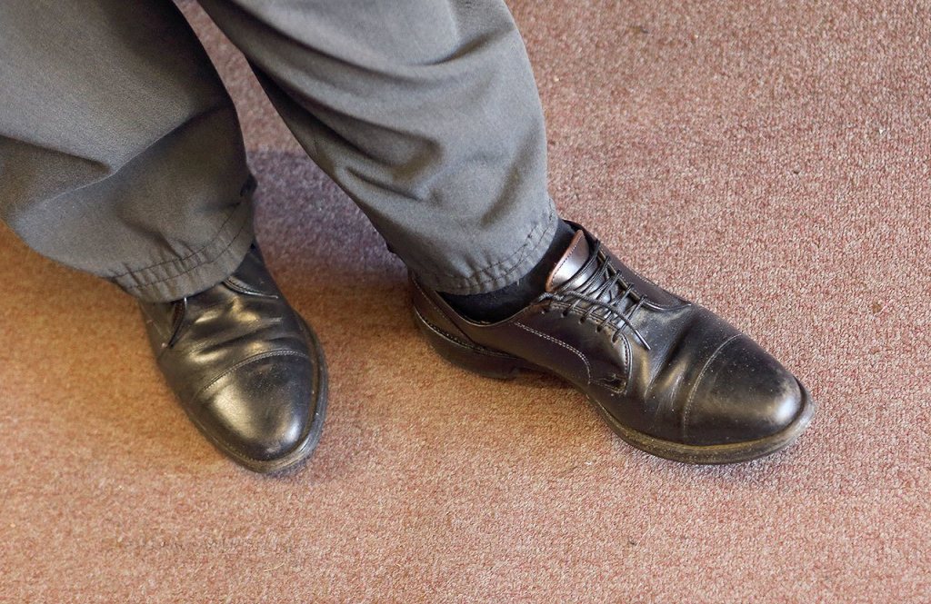Mike Papadimitriou, owner of People&rsquo;s Shoe Repair, wears a pair of American-made Allen Edmonds shoes at his shop. (Andy Bronson / The Herald)