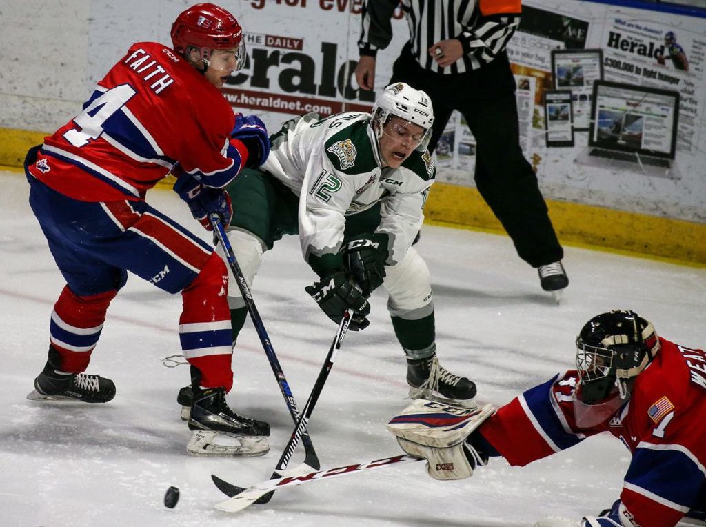 Everett&rsquo;s Bradly Goethals (center) vies for control of the puck with Spokane&rsquo;s Jeff Faith (left) and Spokane&rsquo;s Dawson Weatherill defending during the Silvertips&rsquo; 5-0 win over the Chiefs on Wednesday night at Xfinity Arena in Everett. (Kevin Clark / The Herald)