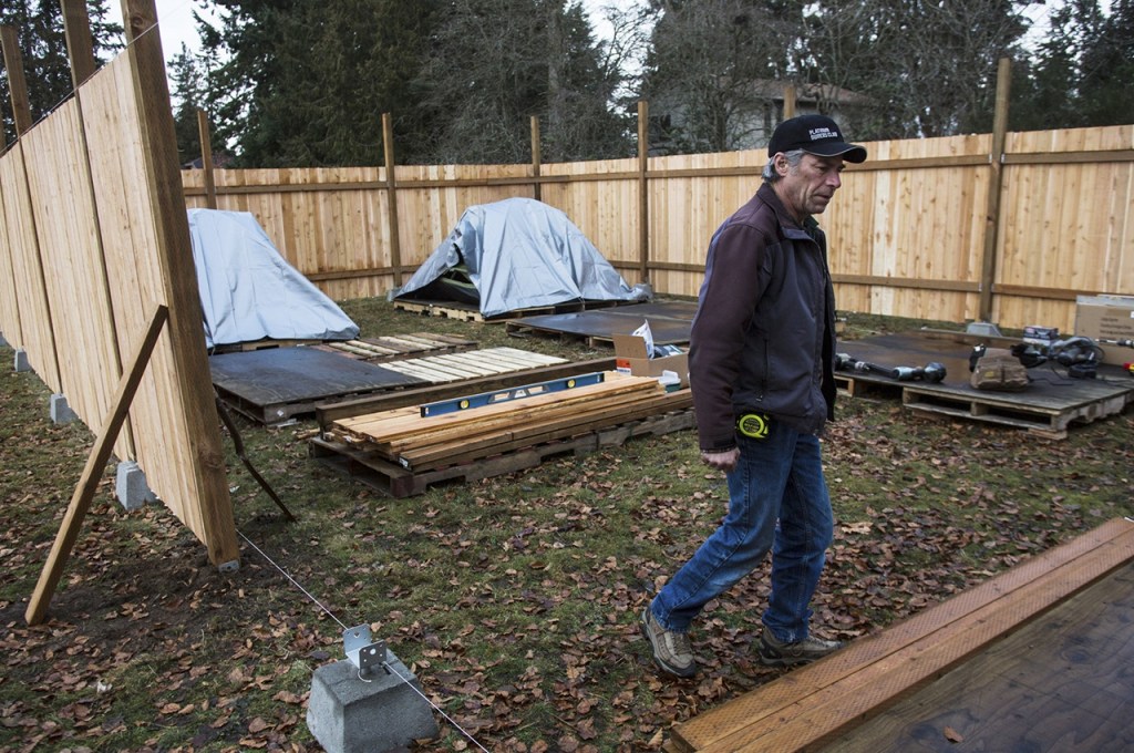 Tony Thompson works on the new homeless students living site at Good Shepherd Baptist Church on Tuesday in Lynnwood. Thompson helped construct the site and is now one of the patrols who provides daily security for the residents. (Daniella Beccaria / The Herald)