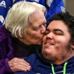 In Snohomish County Superior Court, Tuesday, Terry Robertson of Bow arrives and plants a kiss on her grandson Scotty Becktell, as the paralyzed youth sits waiting for the sentencing of hit-and-run driver, Scott Duncan. (Dan Bates / The Herald)