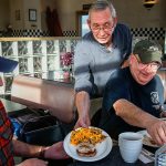 Running the restaurant entirely by himself Tuesday, Joe Weller serves a Speedway Special to Tom Cook (left) and an omelet to Lou Pirone, plus another special and omelet to two more friends, Ben Rico and Tom Lamb, sitting across the table. The men, friends from Lynnwood, are longtime regulars at Weller&rsquo;s. (Dan Bates / The Herald)