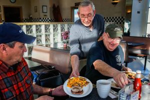 Running the restaurant entirely by himself Tuesday, Joe Weller serves a Speedway Special to Tom Cook (left) and an omelet to Lou Pirone, plus another special and omelet to two more friends, Ben Rico and Tom Lamb, sitting across the table. The men, friends from Lynnwood, are longtime regulars at Weller&rsquo;s. (Dan Bates / The Herald)