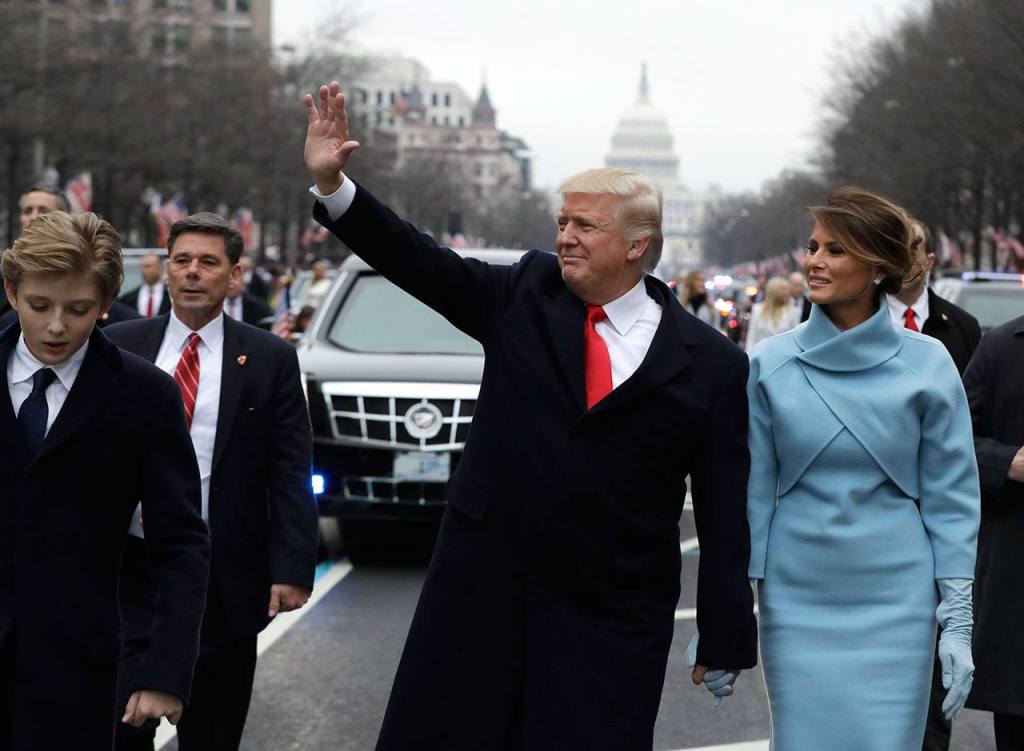 President Trump waves as he walks with first lady Melania Trump and his son Barron during the inauguration parade on Pennsylvania Avenue in Washington on Friday, Jan. 20. (AP Photo/Evan Vucci, Pool)