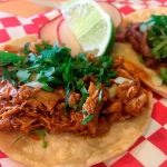 A shredded chicken taco, done in the style of a taco truck with a small tortilla, some cilantro, sliced radish and a lime wedge at Tacobook in Everett. (Ben Watanabe / The Herald)