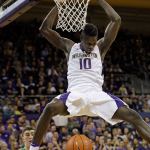 Washington&rsquo;s Malik Dime hangs on the rim after dunking against Oregon in the second half of a Jan. 4 game in Seattle. (AP Photo/Elaine Thompson)
