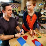 Fourth-grader Kasen Cooley explains the ins and outs of making Valentine&rsquo;s Day cards to Navy veteran Benjamin Studley on Thursday, beginning with gluing on the heart and ending with what to write on it. &ldquo;We have a list of ideas on the wall over there,&rdquo; said the polite 10-year-old, &ldquo;if you need help thinking of something to say.&rdquo; (Dan Bates / The Herald)